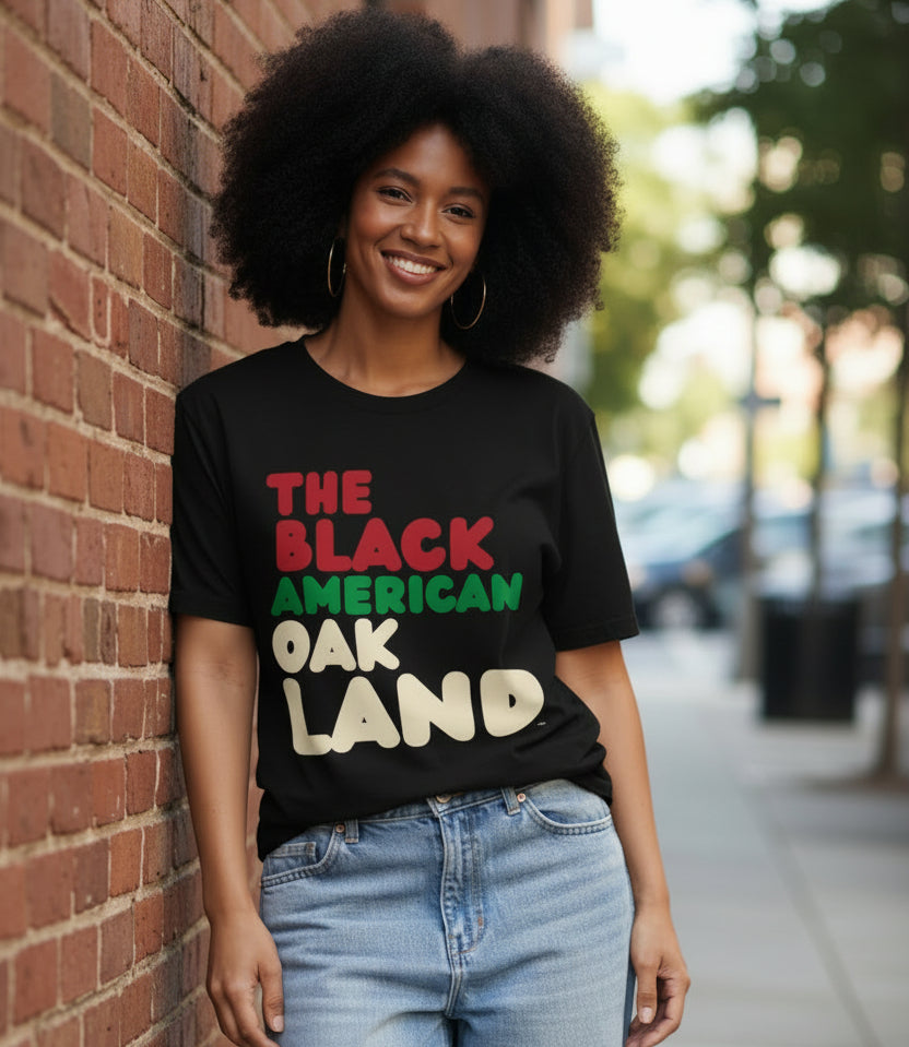 Woman wearing the APWT Gift Shop's the Black American Oakland Premium Unisex T-Shirt from the Black Collection
