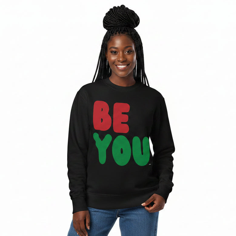 Woman wearing the APWT Gift Shop's Be You in Black Premium Unisex Crew Neck Sweatshirt from the Black Collection