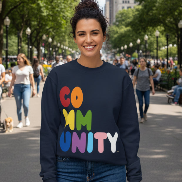 Woman standing in  a city park wearing the APWT Gift Shop's Rainbow Community Premium Unisex Crew Neck Sweatshirt from the Community Collection and the Premium Basics Collection 