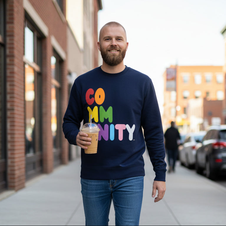 man walking down a city street wearing the APWT Gift Shop's Rainbow Community Premium Unisex Crew Neck Sweatshirt from the Community Collection and the Premium Basics Collection 