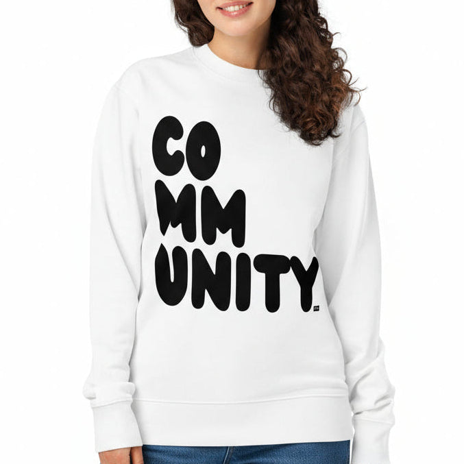 Woman wearing a white sweatshirt with 'COMMUNITY' printed on it against a white background