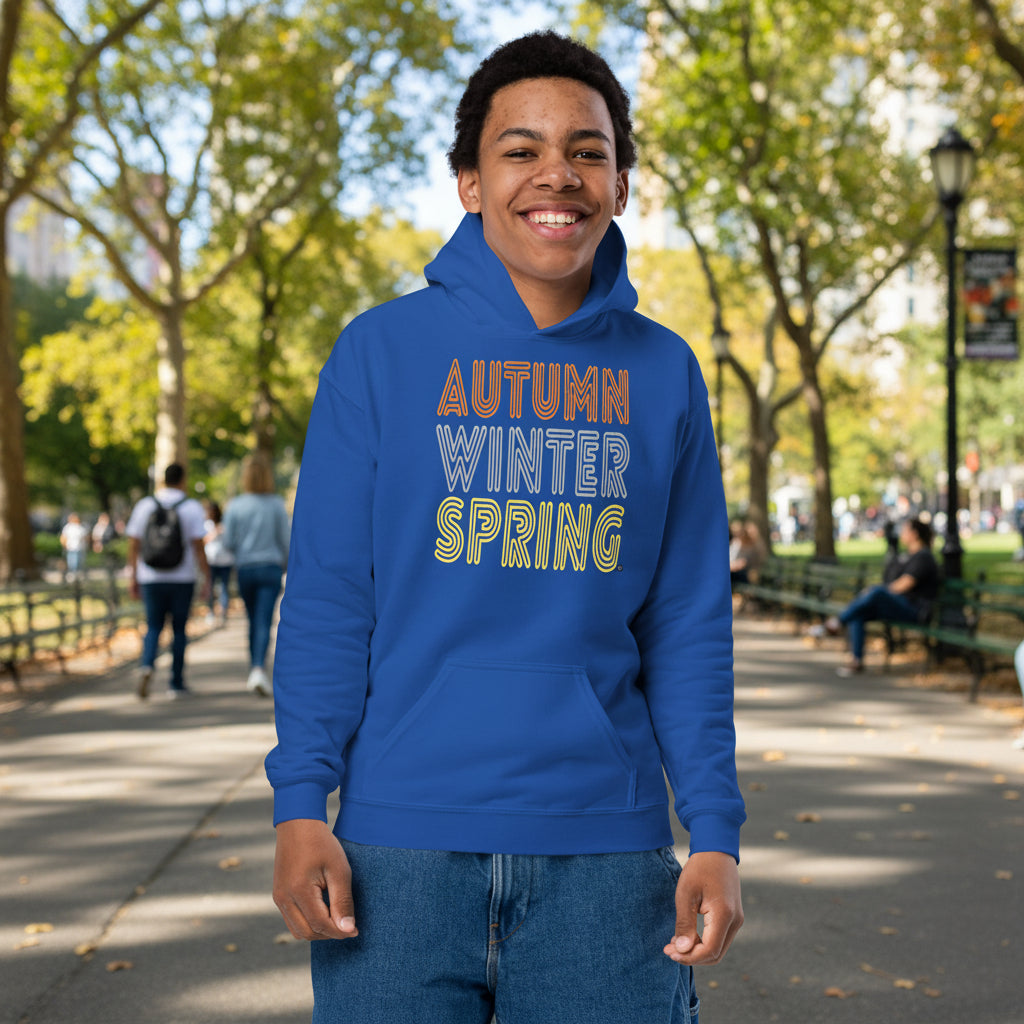 Boy standing in a city park wearing The APWT Gift Shop's Fall into Autumn Kid's Unisex Hoodie in Royal Blue from the APWT Kid's Shop