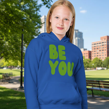 Girl in park wearing Be You Kids in Green Unisex Hoodie in Royal Blue from the APWT Gift Shop -  Kids Affirmation Sweatshirts