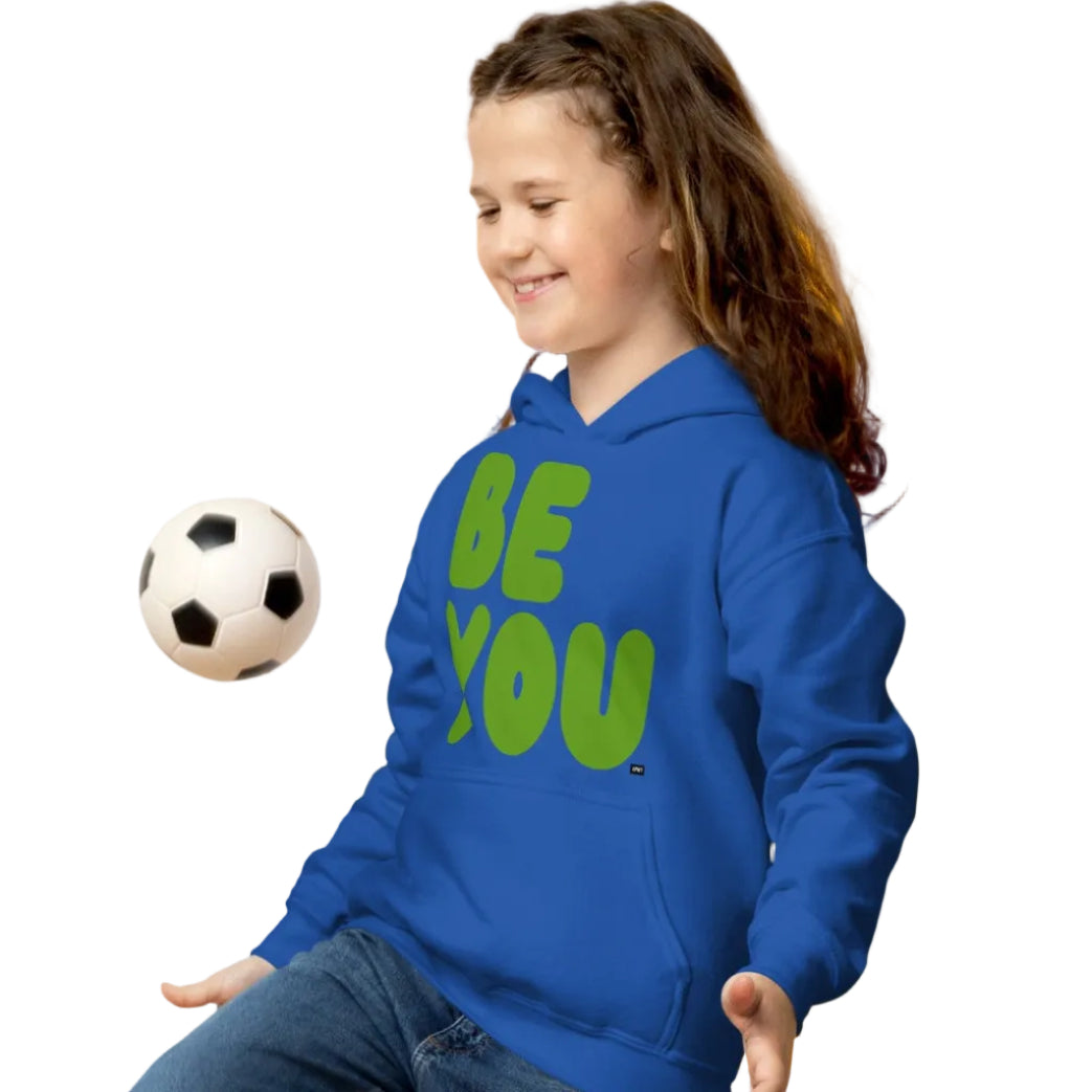 Girl playing with soccer ball wearing Be You Kids in Green Unisex Hoodie in Royal Blue from the APWT Gift Shop -  Kids Affirmation Sweatshirts