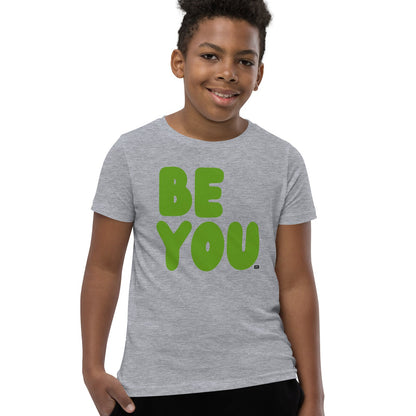 Child wearing a gray t-shirt with 'BE YOU' in green letters on a white background